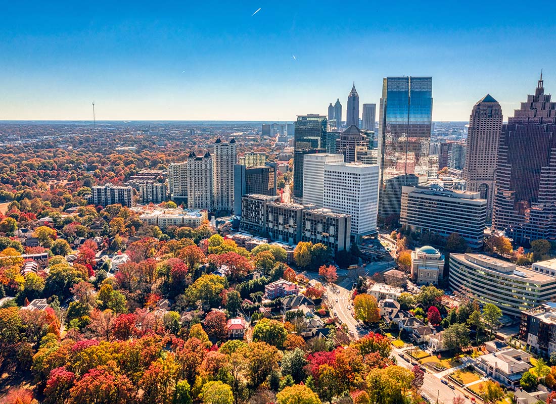 Insurance Solutions - View of Modern Skyscrapers in Downtown Atlanta Georgia Next to a Suburban Neighborhood with Homes Surrounded by Colorful Fall Trees
